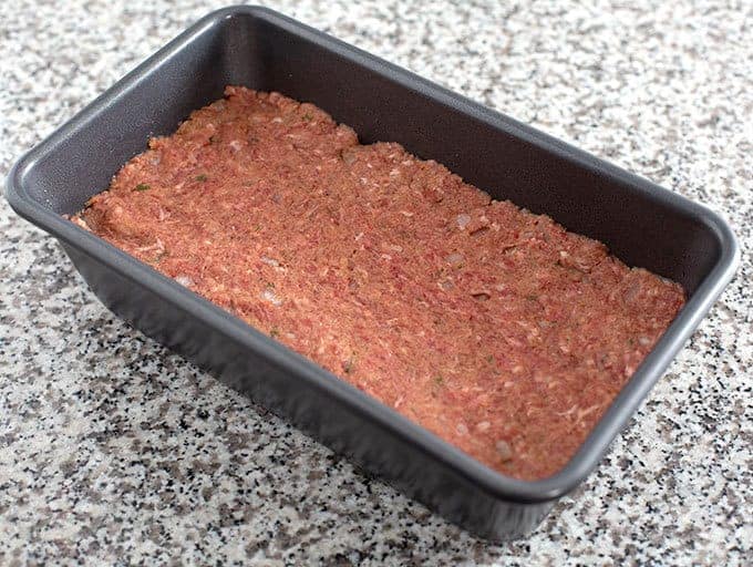 Meatloaf mixture pressed into a loaf pan, ready to bake