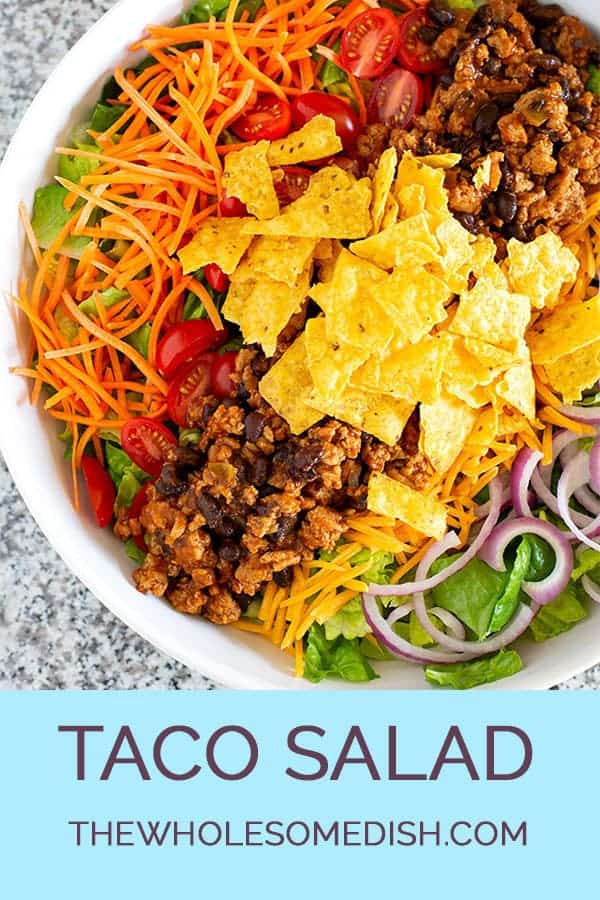 Large bowl of taco salad with crushed tortilla chips on top