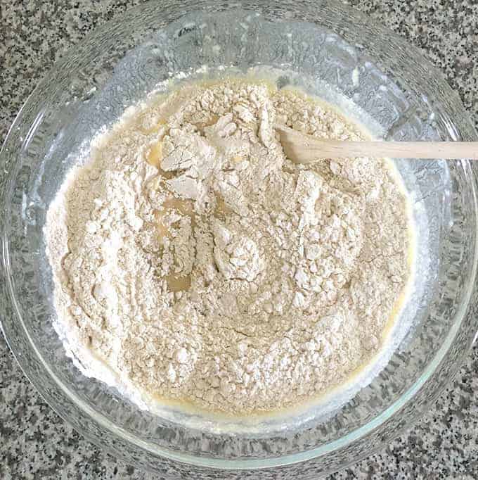 The dry ingredients over the wet ingredients in a bowl of banana bread batter