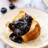 Lemon Blueberry Sauce poured over a slice of angel food cake