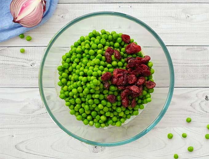 Petite peas and dried cranberries in a bowl for pea salad
