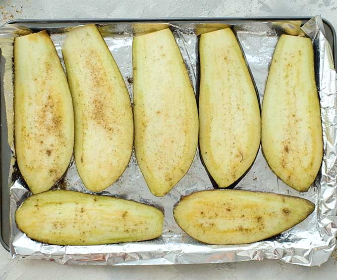 Sliced eggplant on a baking sheet for roasting