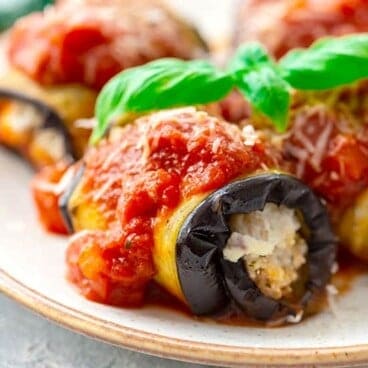 Eggplant involtini stuffed with ricotta and topped with marinara sauce on a plate