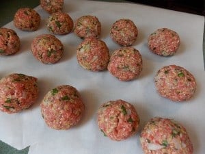 uncooked meatballs on a baking sheet