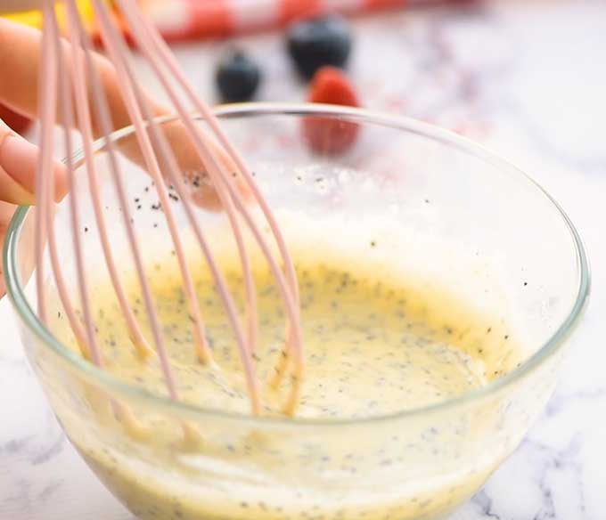 Whisking homemade poppyseed dressing in a bowl