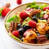 Salad with chicken, berries, and poppyseed dressing in a bowl