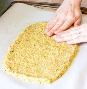 pressing Quinoa Crust dough on a baking sheet