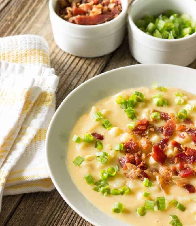 white bowl full of Skinny Crock Pot Loaded Potato Soup and toppings