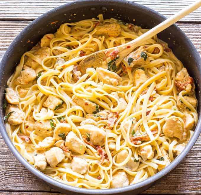 skillet full of Chicken Fettuccini in Sun-Dried Tomato Basil Cream Sauce in a skillet