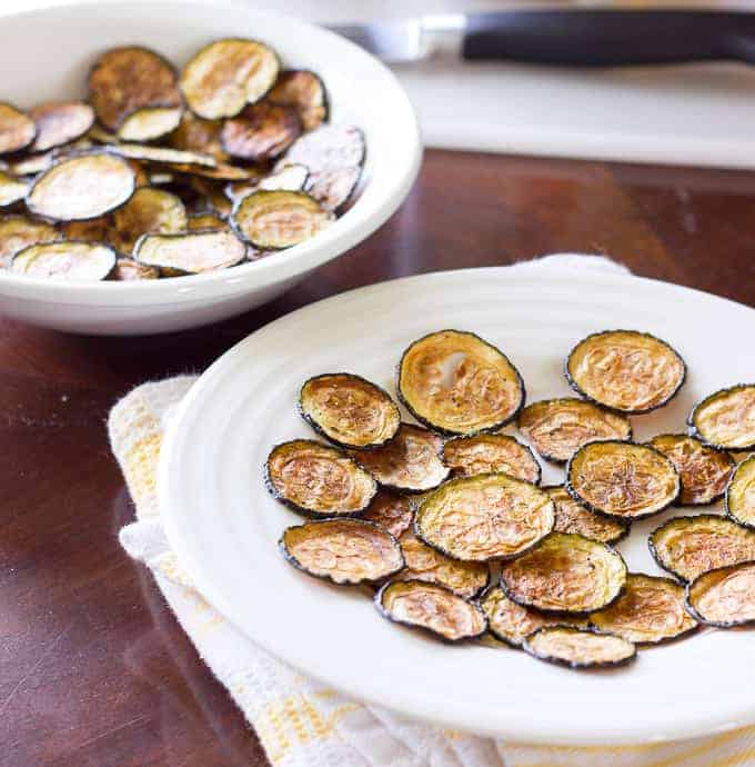 white plate and bowl full of Salt and Vinegar Zucchini Chips