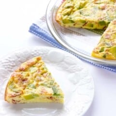 Avocado Bacon Crustless Quiche with one slice taken out on a white plate