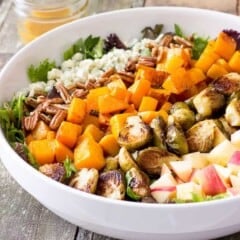 white bowl full of Roasted Butternut Squash & Brussels Sprouts Harvest Salad with Maple Cider Vinaigrette