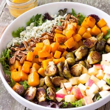 white bowl full of Roasted Butternut Squash & Brussels Sprouts Harvest Salad with Maple Cider Vinaigrette