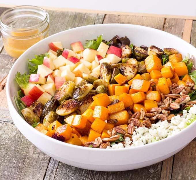 white bowl full of Roasted Butternut Squash & Brussels Sprouts Harvest Salad with Maple Cider Vinaigrette