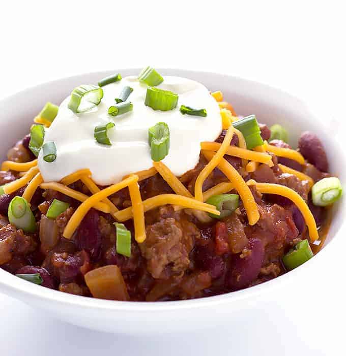 white bowl full of Maple Bourbon Chili with toppings