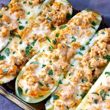 buffalo chicken stuffed zucchini with cheese in a baking dish