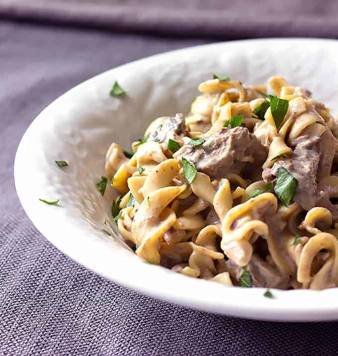 white bowl full of Crock Pot Beef Stroganoff with egg noodles