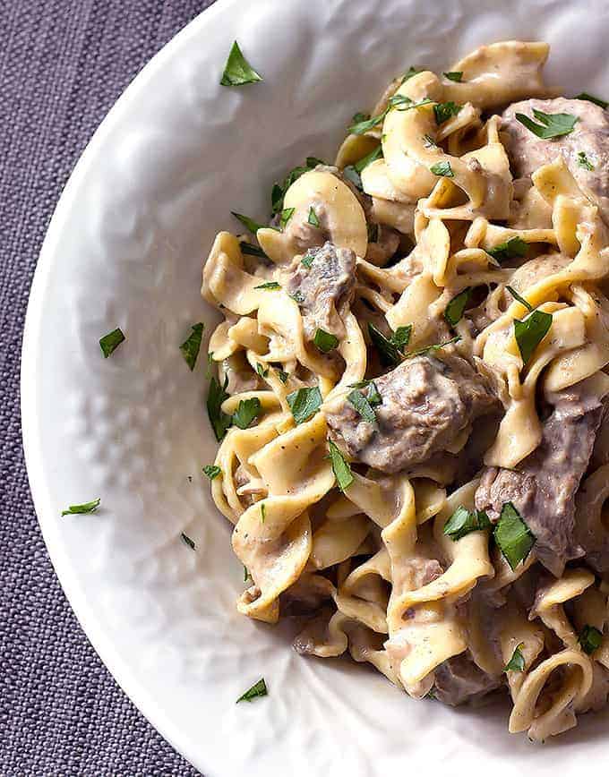 white bowl full of Crock Pot Beef Stroganoff with egg noodles