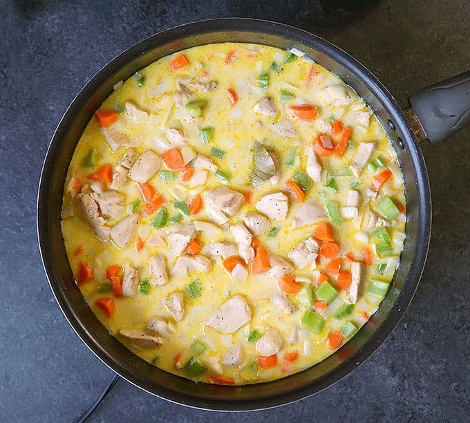 skillet full of uncooked ingredients for One Pot Creamy Chicken and Rice