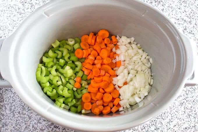 chopped carrots celery and onion in a slow cooker