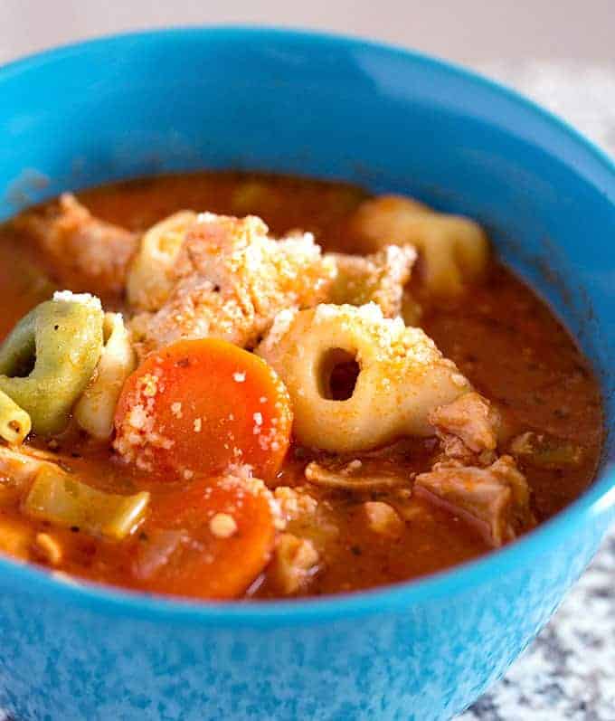 Crock Pot Italian Chicken Tortellini Soup recipe in a blue serving bowl