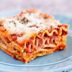 Slice of the best classic lasagna recipe with layers of pasta, homemade meat sauce, ricotta mozzarella and parmesan cheese