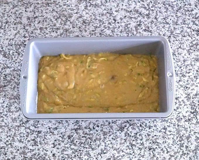 Loaf pan full of zucchini bread batter