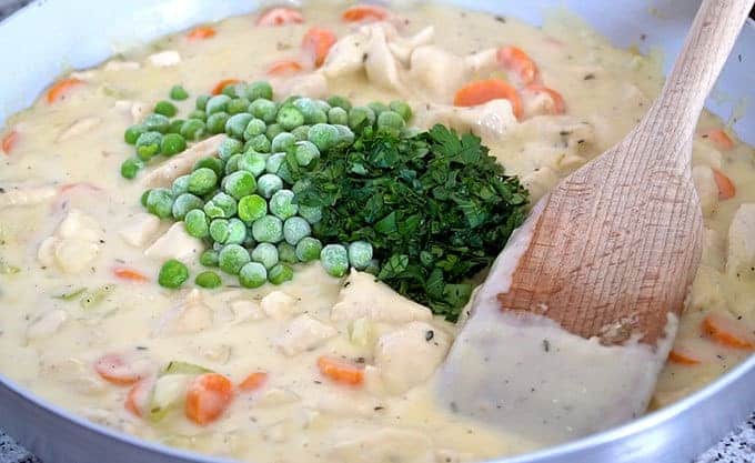 Adding peas and minced fresh parsley into creamy chicken pot pie filling