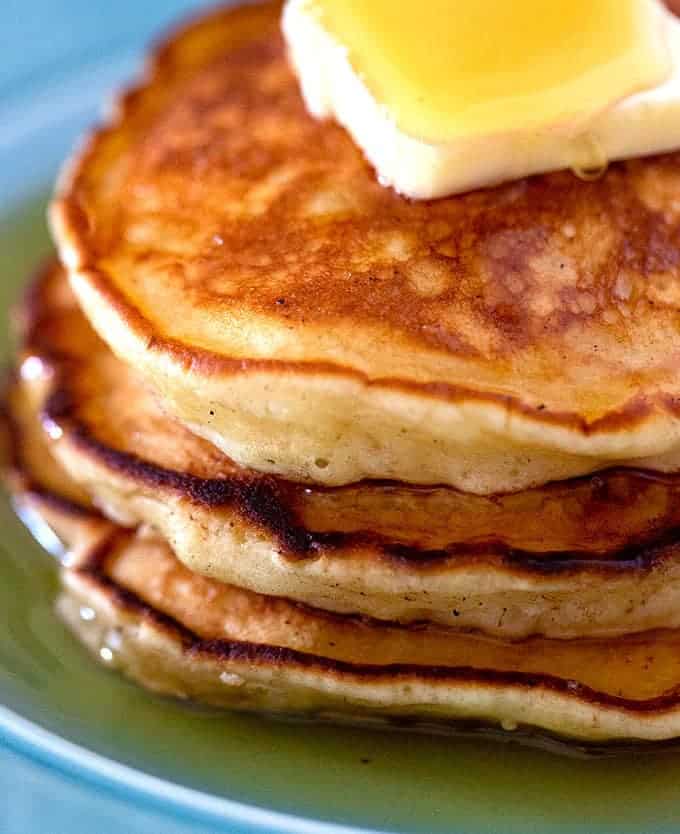 The best pancakes stacked with butter and maple syrup on them