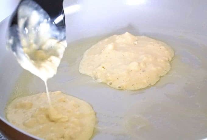 The best pancake batter being poured into a hot buttered skillet