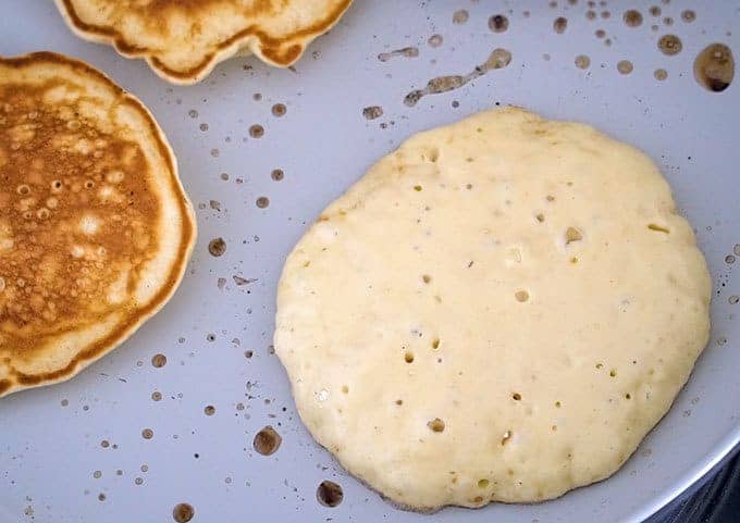 Bubbles forming on the top of pancake batter before flipping over