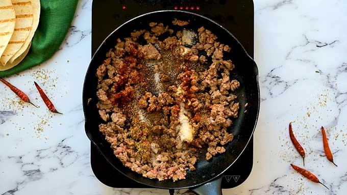 Homemade taco seasoning on ground beef in a skillet