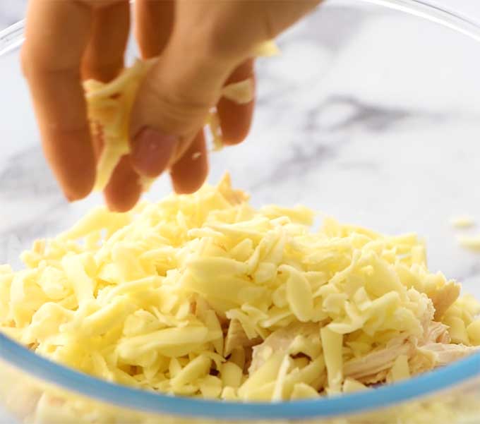 bowl of pulled rotisserie chicken and shredded mozzarella cheese for buffalo chicken dip