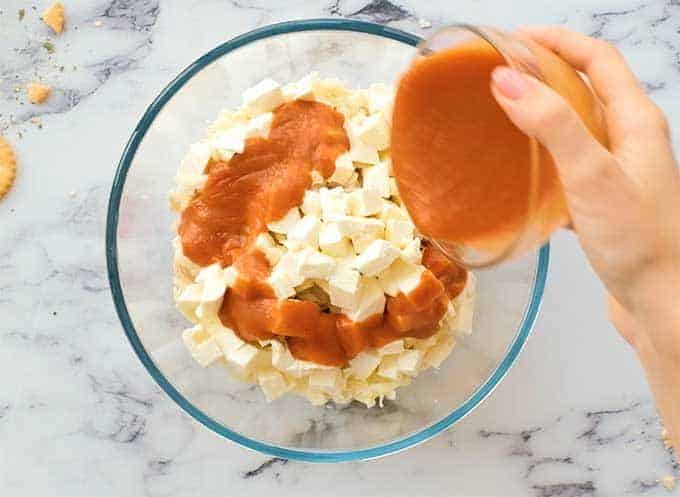 Mixing bowl full of chicken, mozzarella, cream cheese, and buffalo wing sauce