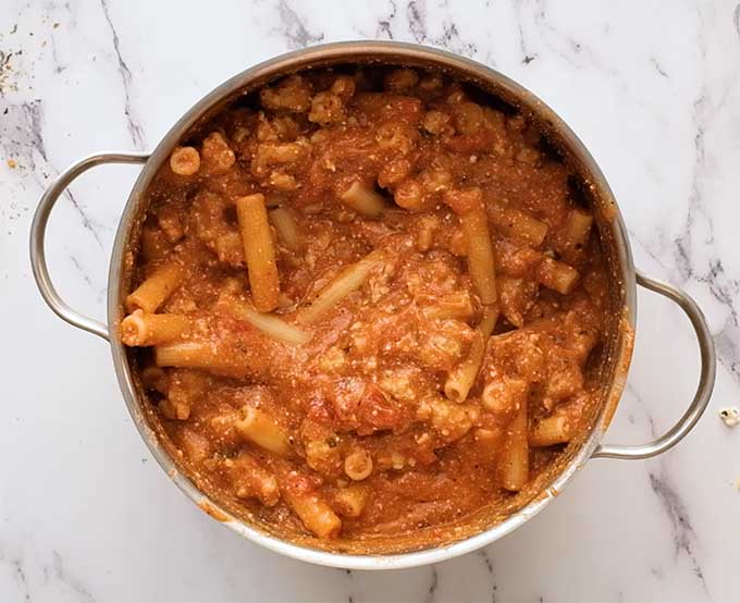 Large pot full of cooked ziti pasta in meat sauce