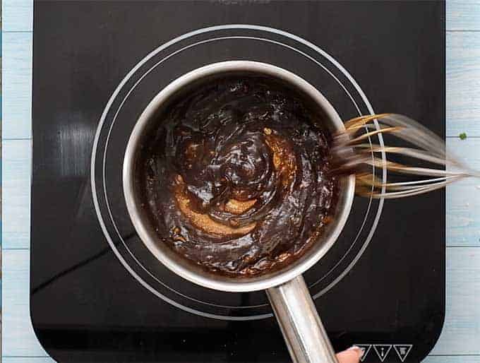 Thick teriyaki glaze being reduced in a small sauce pot