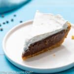 slice of chocolate cream pie with whipped cream on top on a white plate