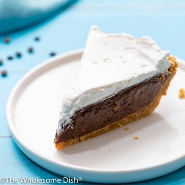 slice of chocolate cream pie with whipped cream on top on a white plate