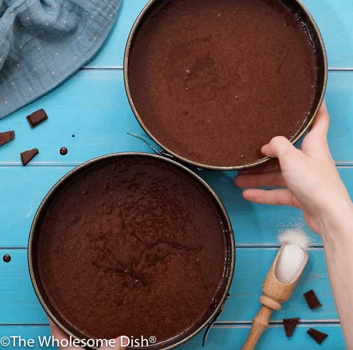 2 round bake pans with chocolate cake batter in them