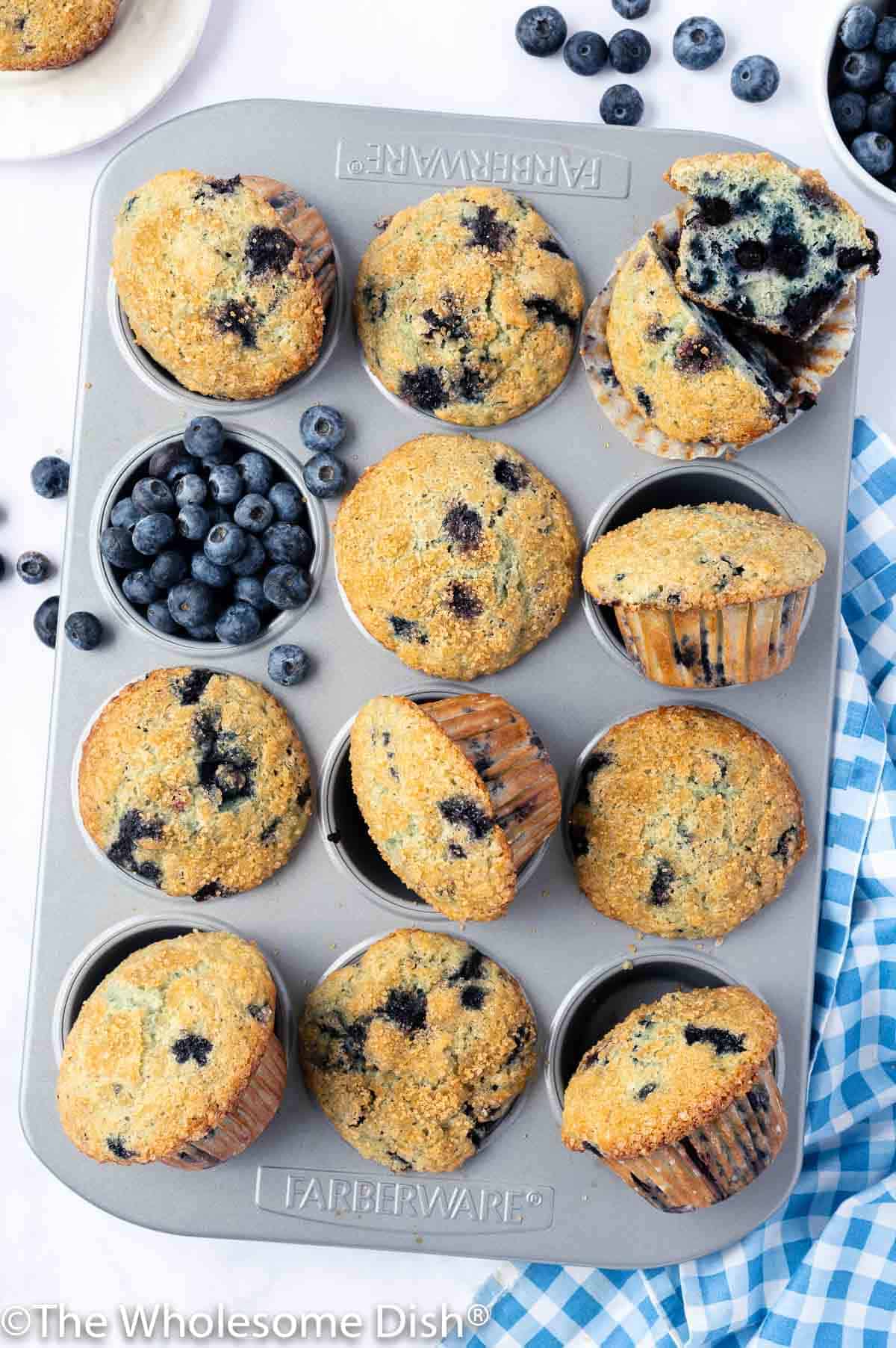 Muffin tin full of baked blueberry muffins.