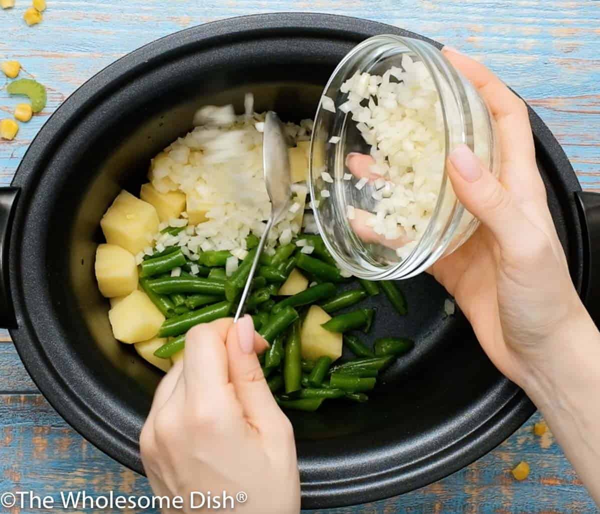 Crock pot full of potatoes, green beans, and onions.