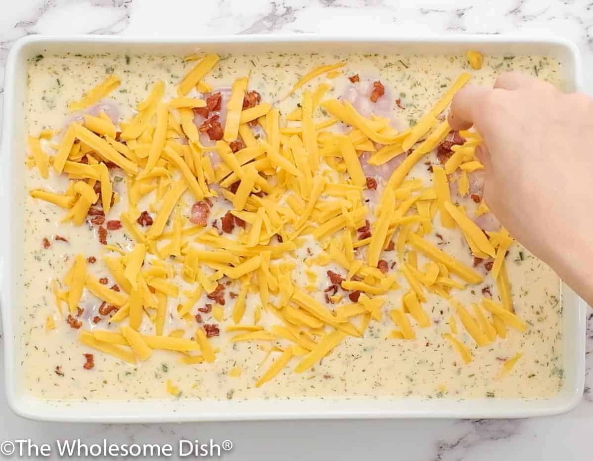 sprinkling cheese over an unbaked chicken and rice casserole.