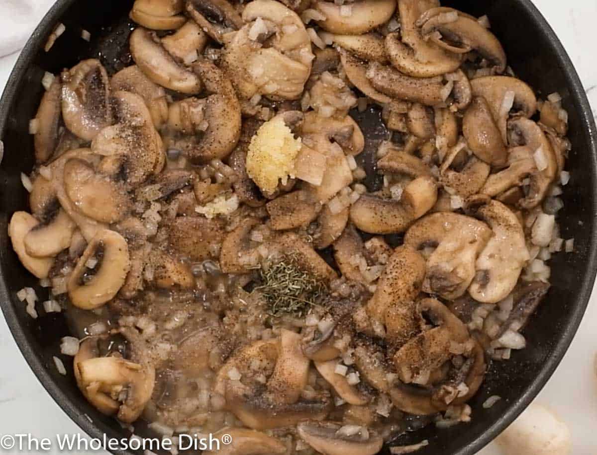 Skillet full of sautéed mushrooms, onions, garlic, and seasonings.