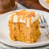 Piece of butterscotch pumpkin poke cake on a white plate.