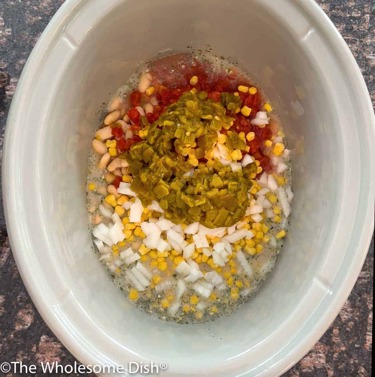 Crockpot with ingredients for white chicken chili.