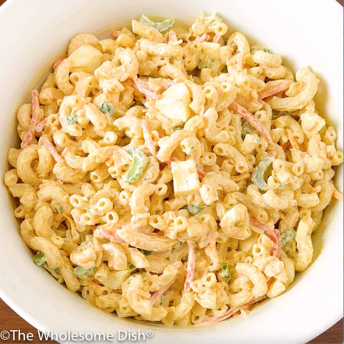 Large white bowl full of macaroni salad.