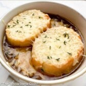 Bowl of French onion soup topped with bread and cheese.