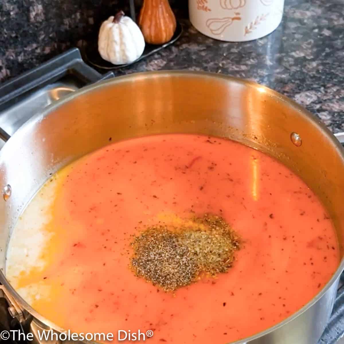 Adding Italian seasoning, garlic powder, salt, and pepper to the pot.