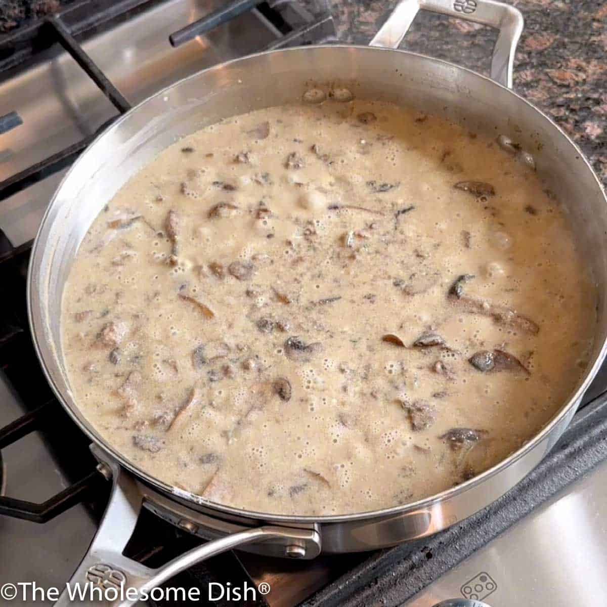 Skillet full of ground beef stroganoff simmering.