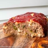 Sliced Philly Cheesesteak Meatloaf on a wood cutting board.